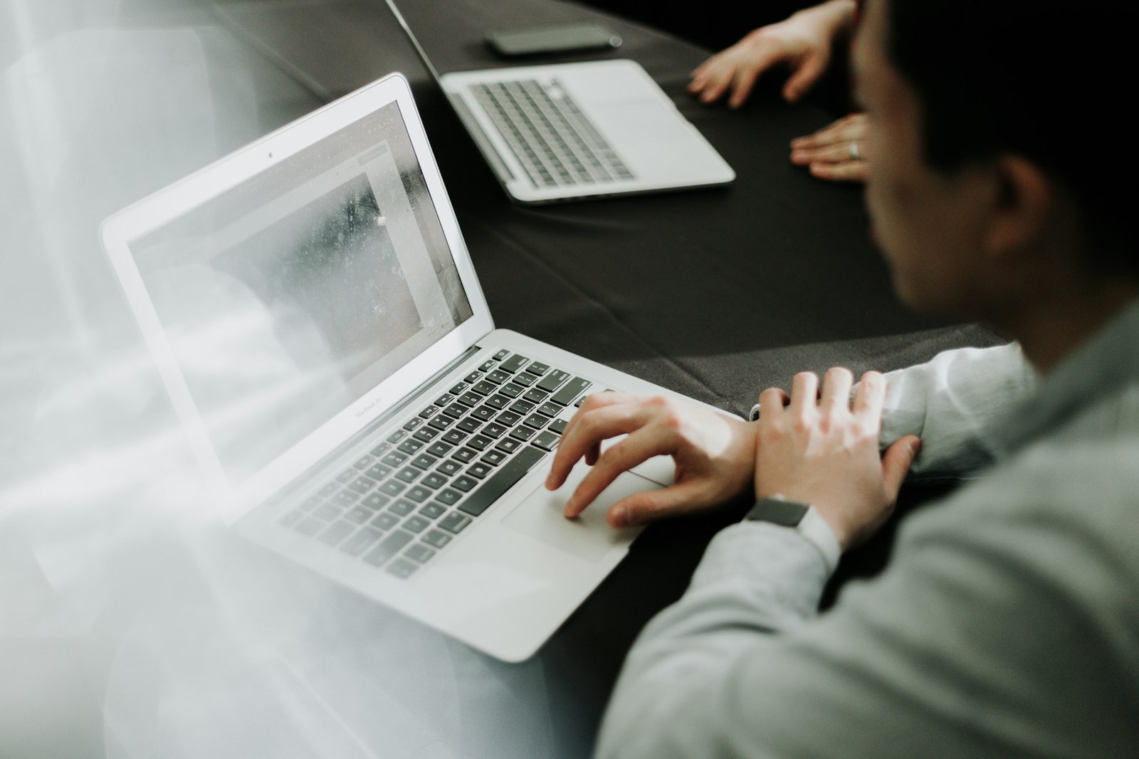 A modern office team working on laptops — the everyday workloads Microsoft 365 licensing covers